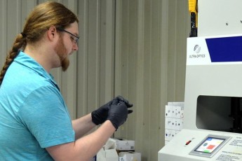 Lab tech at the hard coat machine.